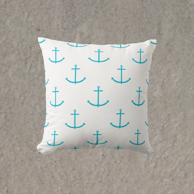 turquoise ankerpatroon kussen (A throw pillow with a pattern of turquoise anchors)