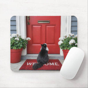Tuxedo kat op een rode welkomstmat muismat