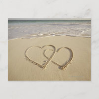 Twee bedekkende die harten op het strand worden
