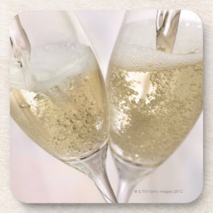 Twee champagnefluten gevuld met mousserende mousse drankjes onderzetter