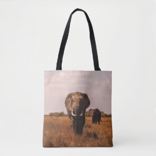 TWEE ELEPHANTS WALKING ON GRASS COVERED GROUND TOTE BAG