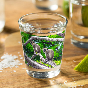 Twee groene apen die in een heet bladerglas zitten shot glas