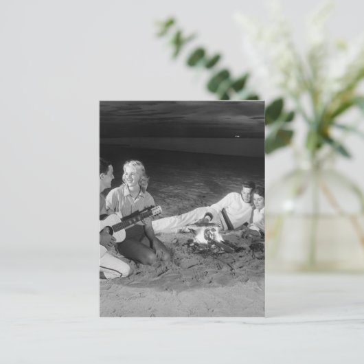 Twee koppels op het strand zitten rond kampvuur briefkaart (Staand voorkant)