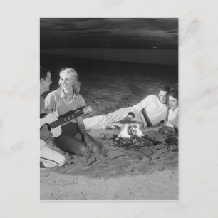 Twee koppels op het strand zitten rond kampvuur briefkaart