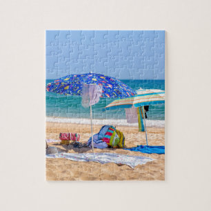 Twee parasols en strandbenodigdheden op zee.JPG Legpuzzel