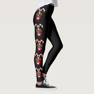 Twee rode en witte feestelijke snoepstokken op zwa leggings