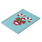 Twee rode en witte snoepjes op blauw notitieboek (Linkerzijde)