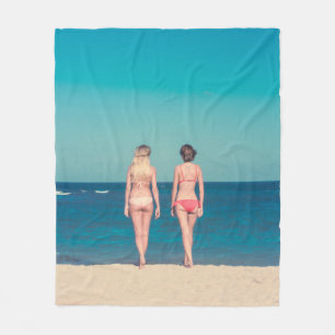 TWEE VROUWEN DIE BIKINI IN STAAT STELLEN OP SHORE FLEECE DEKEN