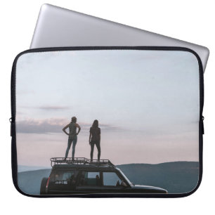 Twee vrouwen staan op het dak van de auto laptop sleeve