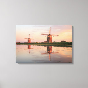 Twee windmolens met reflectie bij zonsondergang canvas afdruk