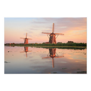 Twee windmolens met reflectie bij zonsondergang foto afdruk