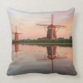 Twee windmolens met reflectie bij zonsondergang kussen
