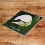 Twee witte Calla Lilies Floral Tegeltje<br><div class="desc">Voor bloem- en plant-liefhebbers! Keramische tegel met een foto-afbeelding van twee,  prachtige witte Calla Lilies en hun groene bladeren. Een mooi,  bloemetjesontwerp! Selecteer de grootte van uw tegel. Maakt een  keukentochtje!</div>