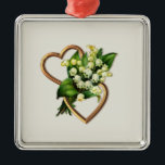 Two Romantic Hearts with White Lilies Metalen Ornament<br><div class="desc">This ornament has two gold entwined hearts with a lily of the valley spray. The open hearts are horizontal with the spray of flowers going through the center. You can add text and change the background color with the personalize options. You will find other items with this patroon in the...</div>