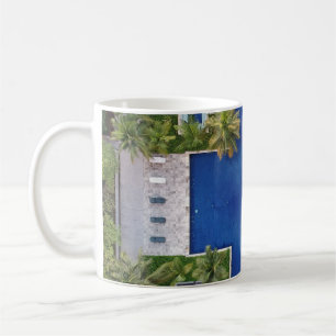 Uitzicht van de pool omringd door palmbomen koffiemok