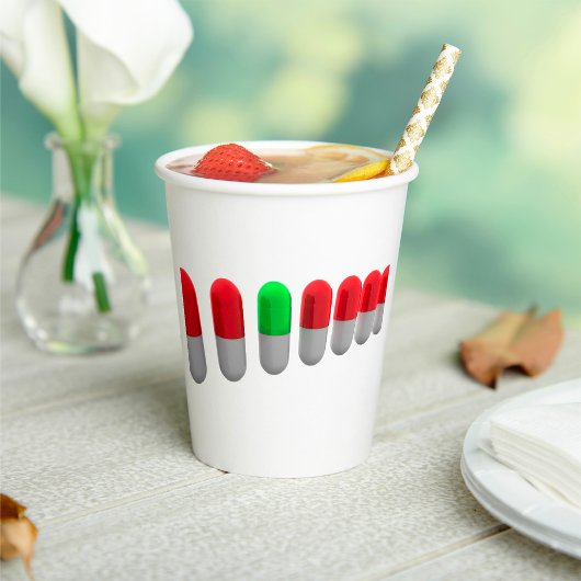 Unieke groene pil tussen rode capsules papieren bekers