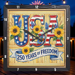 USA 250 Years Freedom Sunflower Vierkante Klok<br><div class="desc">Celebrate a historic quarter-millennium with the "250 Years of Freedom" Sunflower clock. This high-energy timepiece features a high-definition graphic that blends patriotic pride with natural beauty. The design centers on bold, stylized "USA" lettering filled with stars and stripes, prominently accented by vibrant, sun-drenched sunflowers and blue wildflowers. A graceful white...</div>