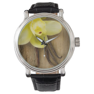 Vanilla Pods and Flower over Wooden Background Horloge