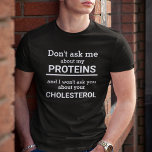 Vegan vraagt me niet naar mijn proteïne gepersonal t-shirt<br><div class="desc">Dit minimalistische leuke T-shirt,  met de aanpasbare tekst "Don't ask me about my proteins and I won't ask you about your cholesterol" in witte letters op een zwarte achtergrond,  is het perfecte cadeau voor elke veganist.</div>