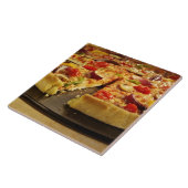 Vegetable pizza gesneden op zwarte pan op hout tegeltje (Zijkant)