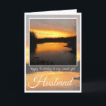 Verjaardag man, Dark Oranje zonsopgang reflectie. Kaart<br><div class="desc">Happy Birthday Husband,  prachtige felle oranje zonsopgang achter gestreepte wolken en duistere bomen,  met oranje en paarse rivierreflectie. Tekst: Gelukkige verjaardag van mijn fantastische man. De binnenste kaart is leeg.</div>