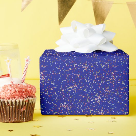Verjaardagstaart strooit op blauw cadeaupapier (Verjaardagsfeest)