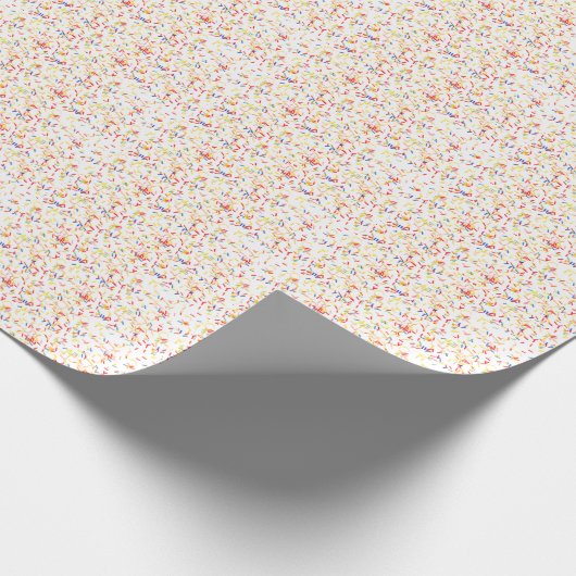 Verjaardagstaart strooit op wit cadeaupapier (Hoek)