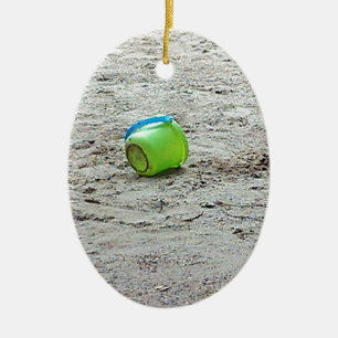 Verloren groene emmer in zand op zomerstrand keramisch ornament