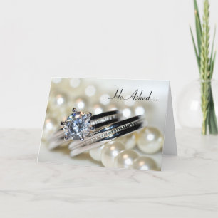 Verlovingsaankondiging met ringen en witte parels aankondiging