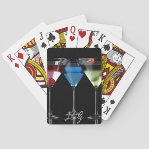 Verschillende cocktails in martiniglazen op zwart pokerkaarten