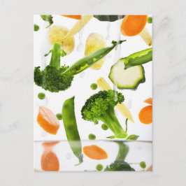 Verse groenten met water dat in een kom valt briefkaart