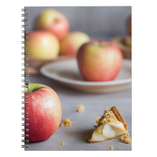 Verse rode appels op tafel, kruimels van appelgeba notitieboek