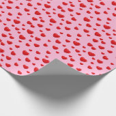 Verspreide rode harten op roze cadeaupapier (Hoek)