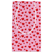 Verspreide rode harten op roze klein cadeauzakje (Voorkant)