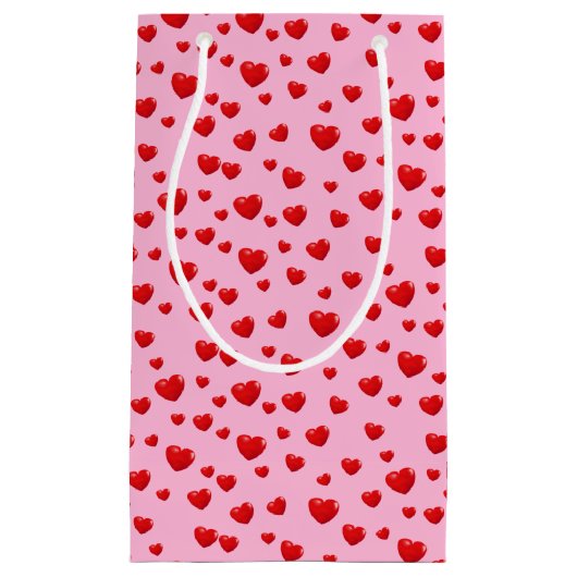 Verspreide rode harten op roze klein cadeauzakje (Voorkant)