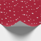 Verspreide witte sterren op rood cadeaupapier (Hoek)