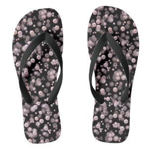 Verspreiding van roze en witte parels op zwarte ve teenslippers