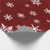 Vette witte sneeuwvlokken op donkere bordeaux rode cadeaupapier (Hoek)