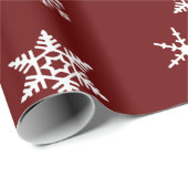 Vette witte sneeuwvlokken op donkere bordeaux rode cadeaupapier (Rol Hoek)
