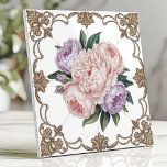 Victoriaans Peony Boeket met Gouden Scrollwork Tegeltje<br><div class="desc">Dit prachtige Victoriaans-geïnspireerde keramische ontwerp beschikt over een delicaat boeket van roze en lavendelpioenen in het midden, omringd door ingewikkeld goudkleurig schuifwerk op een heldere witte achtergrond. Het bloemstuk straalt tijdloze elegantie uit, perfect voor het toevoegen van een vleugje luxe aan keukens, badkamers of decoratieve accenten. De detaillering en zachte...</div>