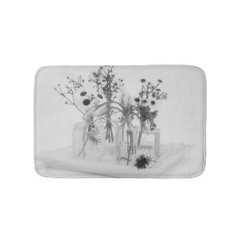 Vier flessen en witte bloemen badmat