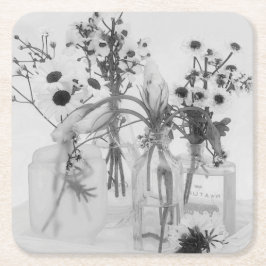 Vier flessen en witte bloemen kartonnen onderzetters