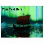 Viking Ship under Northern Lights Fotobeeldje Magneet<br><div class="desc">Een enigszins gestileerd afbeelding van een Viking-beugschip dat 's nachts onder de Noordelijke Lichten vaart,  daar een paar ijsbergen. De meeste bemanningen slapen. Voeg je eigen tekst toe.</div>