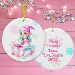 Vintage kerst elf meisje in roze keramisch ornament<br><div class="desc">gepersonaliseerd kerstornament met een schattige retro vrouwen elf in een roze pet omringd door vallende roze en blauwe sneeuwvlokken. De achterkant kan worden gepersonaliseerd met een aangepast bericht.</div>