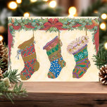 Vintage-kerstvoorraad Feestdagenkaart<br><div class="desc">Prachtig briefkaart met kerstavond. Dit ontwerp bevat drie decoratieve kousen met een heilige tuin.</div>