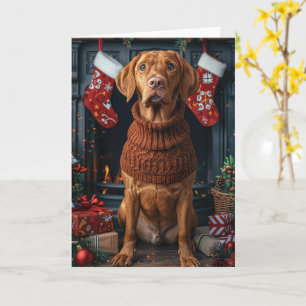Vizsla-hond met kerstcadeaus bij de open haard kaart
