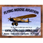 Vliegtuigvlag Staand Fotobeeldje<br><div class="desc">Een weersbordje adverteren de diensten van de mythische Flying Moose Aviation van Talkeetna, Alaska. Het is voorzien van een blauw-en-geel vliegtuig van het bedrijf dat is uitgerust met extra grote "toendra-banden" om op onbewerkt terrein te landen. Tekst, "FLYING MOOSE AVIATION", "We vliegen, vertellen ons waar je heen wilt", "HUNTING, VIST,...</div>