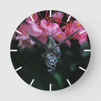Vlinder hangend aan bloemen ronde klok