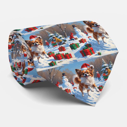 Vlindervlindhond loopt in de sneeuw met kerstmuts stropdas (Opgerold)