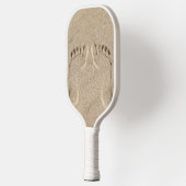 Voetafdrukken op het strand in het zand pickleball paddle (Links)
